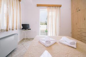 a bedroom with a bed with two towels on it at Creta Sea View 2BR Maisonette by ΜΡS in Marathokefála