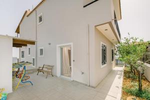 a white house with a patio with a table at Creta Sea View 2BR Maisonette by ΜΡS in Marathokefála