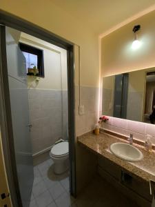 a bathroom with a toilet and a sink and a mirror at Hostel Nueva cordoba Subte Uno in Córdoba +61 photos