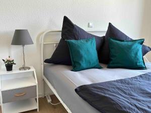 ein Schlafzimmer mit einem Bett mit blauen Kissen und einer Lampe in der Unterkunft 1,5 Zimmer für 4 Personen auf 38qm Wohnfläche in Niederdorla