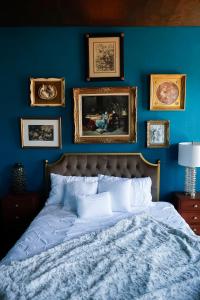 een blauwe slaapkamer met een bed en foto's aan de muur bij The Lincoln House Inn in Bowling Green