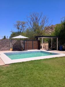 einen Pool im Garten mit Sonnenschirm in der Unterkunft La cañada in Belén