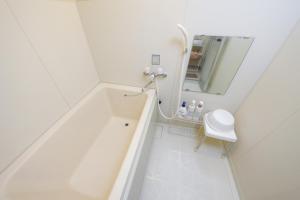 uma casa de banho branca com uma banheira e um espelho. em Duetoir 801 / Vacation STAY 7558 em Nagoya mais 11 fotografias