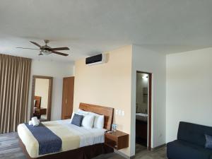ein Schlafzimmer mit einem Bett und einem blauen Stuhl in der Unterkunft Hotel Piedra del Caribe Puerto Morelos in Puerto Morelos + 78 Fotos