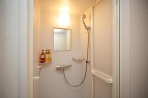 a bathroom with a shower and a mirror on the wall at Dormy Inn Nagano in Nagano