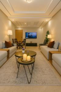 a living room with two couches and a tv at Confort et Piscine, à 5 min de Rabat et Aéroport in Sale