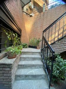 a staircase leading up to a brick building with plants at Hostel Nueva cordoba Subte Uno in Córdoba