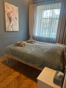 a bed sitting in a room with a window at Cozy Apartment- Self Check- In in Riga