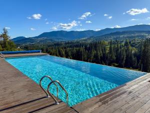 a swimming pool with a view of the mountains at Eho Resort in Ilʼtsya Gurny