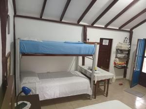 ein Zimmer mit zwei Etagenbetten und einem Tisch in der Unterkunft Cabaña Refugio in Buena Vista