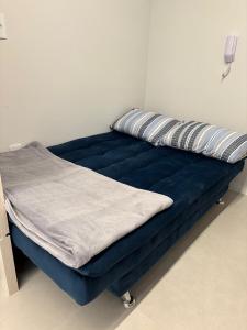 a blue bed with a pillow on top of it at Loft com Piscina no Rooftop centro de Blumenau in Blumenau +34 photos