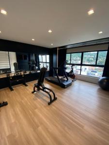 a gym with exercise equipment in a room with wood floors at Loft com Piscina no Rooftop centro de Blumenau in Blumenau