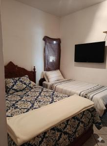 a room with two beds and a flat screen tv at Chácara maravilha in Monte Sião