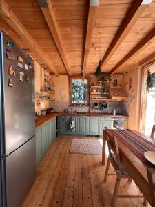 eine Küche mit einem Kühlschrank und einer Holzdecke in der Unterkunft Cozy frame house in the wood  + 17 Fotos