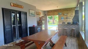 a room with a wooden table and a fireplace at Chácara maravilha in Monte Sião +3 photos