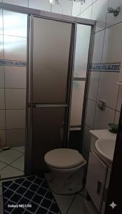 a bathroom with a shower with a toilet and a sink at Chácara maravilha in Monte Sião