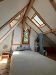 ein Schlafzimmer mit einem großen Bett im Dachgeschoss in der Unterkunft Cozy frame house in the wood 