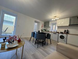 een keuken en woonkamer met een tafel en stoelen bij Charming Seaside Flat in Paul do Mar +36 foto's