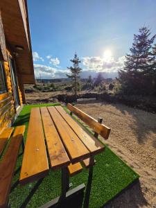 a wooden bench sitting on grass next to a building at 4 BEARs in Kovačka Dolina