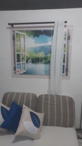 a living room with a couch and a window at Casa Pousadinha Mel in Salvador