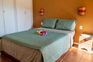 a bedroom with a bed with a bouquet of flowers on it at Apartamento Resort Cabo Frio - Rua dos Biquinis in Cabo Frio +27 photos