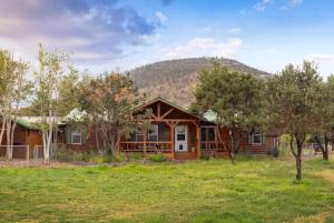 a log home with a mountain in the background at The Shady Grove Retreat in South Fork