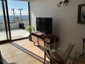 ein Wohnzimmer mit Glastisch und Fernseher in der Unterkunft Maravilloso Dep Amarilla Beach in Concón