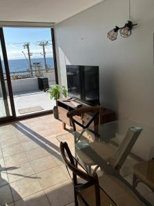 ein Wohnzimmer mit Glastisch und Fernseher in der Unterkunft Maravilloso Dep Amarilla Beach in Concón