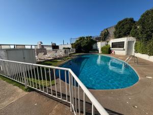 ein Schwimmbecken mit weißem Geländer neben einem Wohnmobil in der Unterkunft Maravilloso Dep Amarilla Beach in Concón