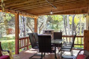 a deck with a table and chairs with a computer on it at The Shady Grove Retreat in South Fork