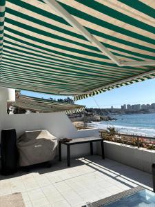 eine Terrasse mit einem Tisch unter einem großen Sonnenschirm in der Unterkunft Maravilloso Dep Amarilla Beach in Concón