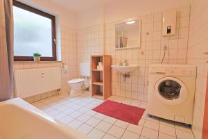 Ferienwohnung in Lohfelden nahe Kassel في لوهْفيلدِن: حمام مع غسالة ومغسلة +39 صورة