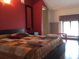 MelにあるAl Cavallino Rossoの赤い壁のベッドルーム1室(大型ベッド1台付)