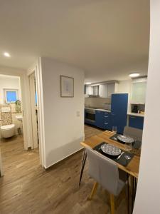 une cuisine et un salon avec une table et des chaises dans l'établissement Modernes Apartment im Zentrum, à Kirchheim unter Teck