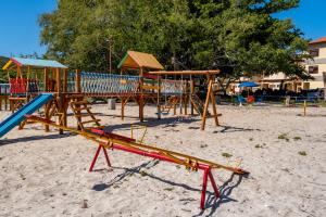 a playground with wooden play equipment in the sand at Apartamento Resort Cabo Frio - Rua dos Biquinis in Cabo Frio