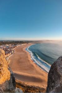 a view of the beach from a cliff at Nazaré Stay Home - Alecrim T2 in Nazaré