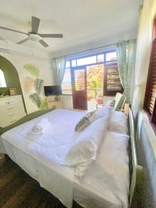 a large white bed in a room with windows at Paradise View in Gros Islet