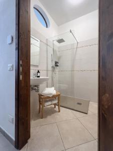 ein Badezimmer mit einer Dusche und einer Bank neben einem Waschbecken in der Unterkunft Pascoli 21/A in Ravenna + 39 Fotos
