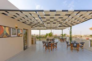 a patio with tables and chairs on a balcony at Seven Stays New Cairo in Cairo