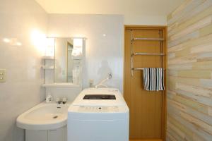 a white bathroom with a sink and a mirror at Dai6 Prosper Building, 2nd floor - Vacation STAY 74808v in Nagoya