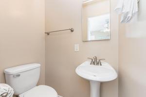 a white bathroom with a toilet and a sink at Pet-Friendly 3Br W Ac & Rooftop Deck 2 Houses From Beach By Beachview Rentals in Newport Beach +21 photos