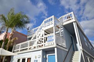 a white balcony on the side of a building at Pet-Friendly 3Br W Ac & Rooftop Deck 2 Houses From Beach By Beachview Rentals in Newport Beach
