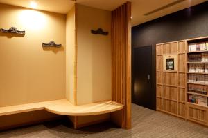 a library with a book shelf at Dormy Inn Nagano in Nagano