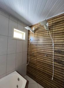 a shower in a bathroom with a window at Casa com piscina a 300m praia in Imbituba