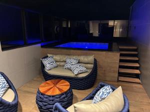 a living room with a couch and a swimming pool at V-Home Flat Hotel in Macaé