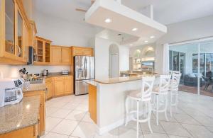 eine Küche mit Holzschränken und weißen Arbeitsplatten in der Unterkunft Palm Pointe - Waterfront Vacation Rental Cape Cora in Matlacha