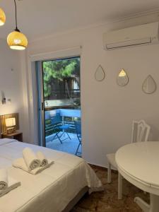 1 dormitorio con cama, mesa y patio en Boho Coastal Retreat with Jacuzzi, 1 min to Beach, en Atenas