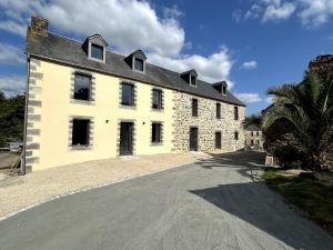un gran edificio de ladrillo blanco con techo negro en Le Sillage Vert, en Rosnoën
