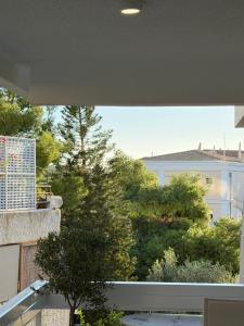 un balcón con vistas a los árboles y a un edificio en Boho Coastal Retreat with Jacuzzi, 1 min to Beach, en Atenas