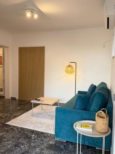 Una sala de estar con un sofá azul y una mesa. en Boho Coastal Retreat with Jacuzzi, 1 min to Beach, en Atenas
